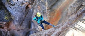 A person rapelling down a slot canyon