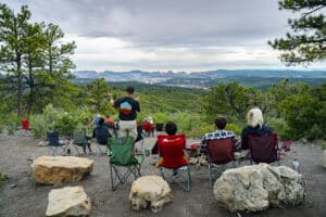 A group of people enjoying a sunset overlooking cliffs