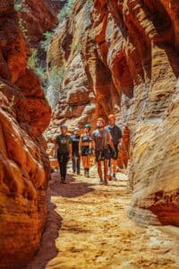 people hiking through a canyon in zion
