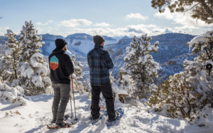 Winter in East Zion 5 Two people snowshoeing with Checkerboard Mesa in the distance